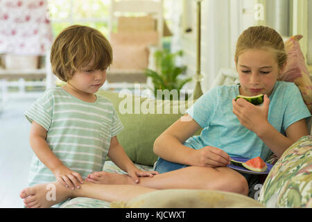 Kaukasische Bruder und Schwester Ansehen digitalen Tablet auf dem Sofa Stockfoto