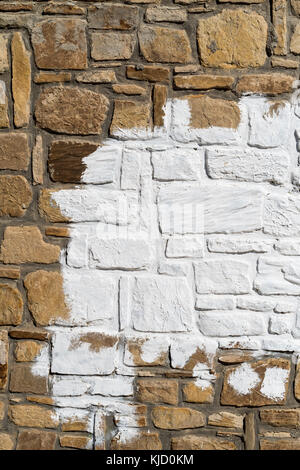 Alte Steinmauer und weiße Farbe in der Mitte Hintergrund Textur Stockfoto