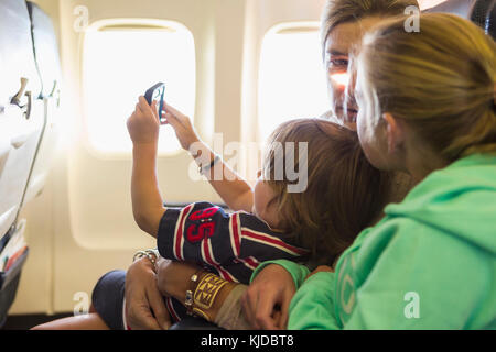 Kaukasische Familie sitzt auf Flugmodus Stockfoto