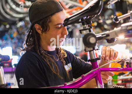 Mann Reparatur Fahrrad im shop Stockfoto