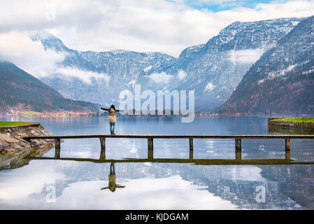 Urlaub Reiseziele Thema Bild einer Frau mit offenen Armen Genießen der wunderschönen Hallstätter See und die Gipfel der Dachstein, in Hallstatt Stockfoto