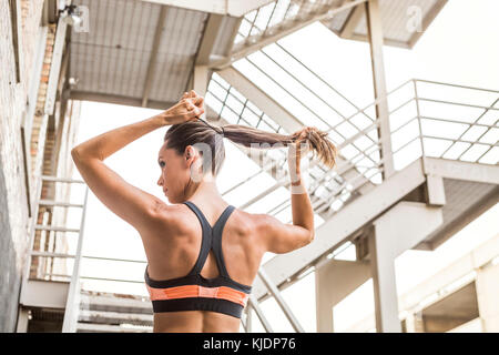 Kaukasische Frau Haar in Pferdeschwanz binden Stockfoto