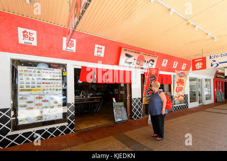 Reife Frau im Menü außerhalb Zipang, einem Japanischen Restaurant mit Sushi, Cairns, Far North Queensland, FNQ, QLD, Australien suchen Stockfoto