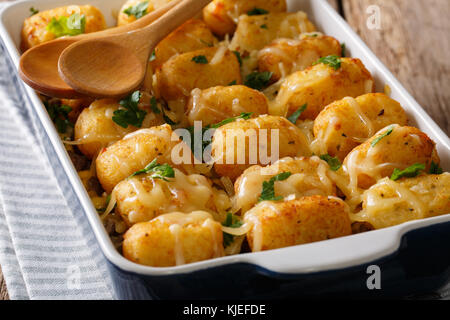 Heiße gebackene Tater Tots mit Käse, Fleisch, Mais und Petersilie close-up in einer Auflaufform auf den Tisch. Horizontale Stockfoto