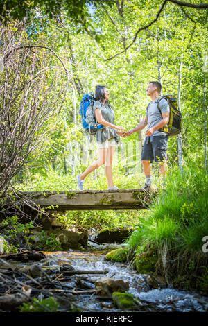 Paar Rucksäcke tragen über Brücke in Holz Stockfoto