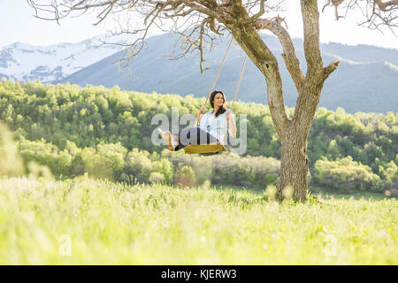 Kaukasische Frau schwingen auf Baum schwingen Stockfoto