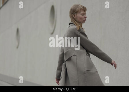 Wind die Haare der kaukasischen Frau mit Mantel Stockfoto