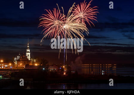 Bunte Feuerwerke in den Himmel über der Stadt und dem Fluss mit Spiegelungen im Wasser, Schuß auf eine lange Belichtung Stockfoto