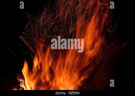 Rot und Orange fire Hintergrund von Flammen und Funken vom Lagerfeuer in Form von Tracks auf schwarzem Hintergrund Stockfoto