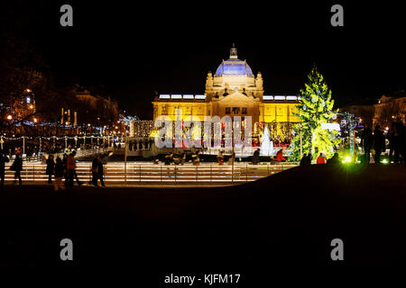 Zagreb, Kroatien: 30 decemer 2015: Eislaufbahn an ledeni Park in der Nacht im Winter mit Blick auf den Pavillon mit Besucher Skaten rund um den Springbrunnen Stockfoto