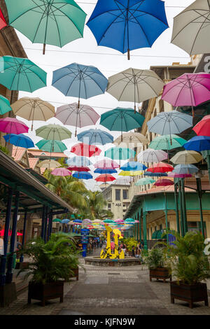 Bunte Regenschirme hängen über dem Einkaufszentrum Caudan Waterfront in Port Louis, Mauritius, Afrika. Stockfoto