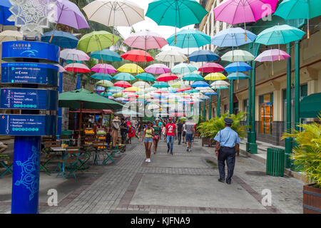 Bunte Regenschirme hängen über dem Einkaufszentrum Caudan Waterfront in Port Louis, Mauritius, Afrika. Stockfoto