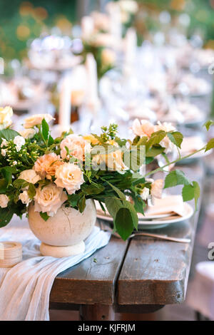 Florale Muster, Hochzeit, Sommer Konzept. in der Nähe von nicht groß ordentlich Blumenstrauß aus schicke Frische wunderbare Blumen benannt Rosen Lawinen im Licht peachy Farbe auf dem Holz- vintage Tisch Stockfoto