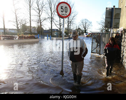 In Mountmellick, Co Laois, laufen Menschen durch Hochwasser, nachdem drei Flüsse ihre Ufer sprengen und Dutzende von Häusern überschwemmt haben. Stockfoto