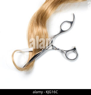 Lange blonde Haare und Schere auf weißem Hintergrund Stockfoto