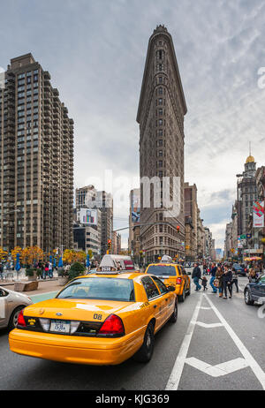 Taxis in einer Straße mit dem Flatiron Gebäude im Hintergrund Stockfoto