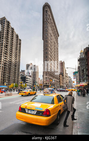 Taxis in einer Straße mit dem Flatiron Gebäude im Hintergrund Stockfoto