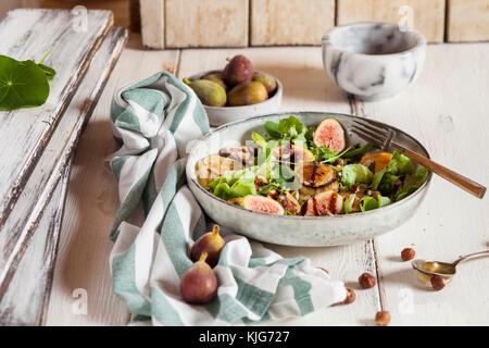 Platte mit grüner Salat mit Feigen, Crema di Balsamico, Honig, Haselnüsse und gebackenen Ziegenkäse Stockfoto