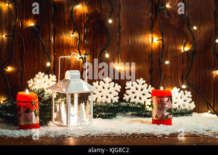 Weihnachten Kerze Laterne und Weihnachtsbaum Zweige, Schnee, Schneeflocken und Dekorationen auf bokeh Hintergrund verschwommen Lichter. freier Speicherplatz Stockfoto