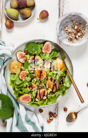 Platte mit grüner Salat mit Feigen, Crema di Balsamico, Honig, Haselnüsse und gebackenen Ziegenkäse Stockfoto