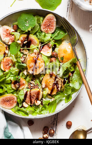 Platte mit grüner Salat mit Feigen, Crema di Balsamico, Honig, Haselnüsse und gebackenen Ziegenkäse Stockfoto