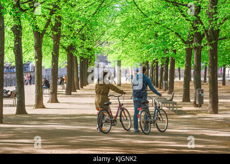 Berliner Jugendliche, Blick auf einen späten Frühlingsnachmittag eines jungen Paares, das seine Räder durch den Lustgarten in Berlin schiebt. Stockfoto