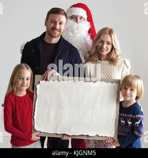 Weihnachten Portrait von Glücklich lächelnde Familie mit zwei Kindern und Santa Claus umarmen Sie sie leer vintage Papier Stockfoto