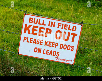 Stier im Feld halten Sie bitte Hunde an der Leine Warnschild auf einem Bauernhof. Stockfoto