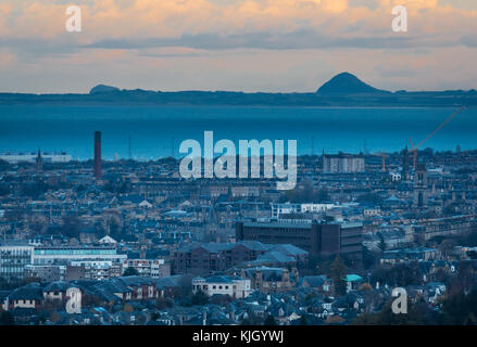 Edinburgh, Schottland, Großbritannien, 23. November 2017. Blick über die Skyline von Edinburgh bei wenig Sonnenlicht in der Dämmerung Blick nach Osten in Richtung Stadtzentrum, mit den markanten Konturen der vulkanischen Stecker von Berwick Law und Bass Rock in der Ferne von Rest und dankbar Aussichtspunkt Stockfoto