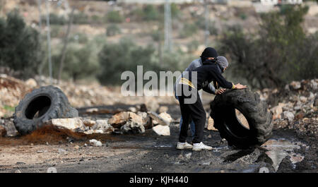 Nablus, Westjordanland, Palästinensische Autonomiegebiete. November 2017. Palästinensische Demonstranten Rollen bei Zusammenstößen mit israelischen Sicherheitskräften nach einer wöchentlichen Demonstration gegen die Enteignung palästinensischen Landes durch Israel im Dorf Kfar Qaddum, in der Nähe von Nablus im besetzten Westjordanland, am 24. November 2017 einen Reifen auf.Quelle: Shadi Jarar'Ah/APA Images/ZUMA Wire/Alamy Live News Stockfoto