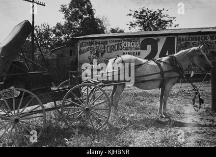 Schwarz-weiß-Fotografie einer Pferdekutsche, die vor einer Werbeseite für einen Zirkus steht, von Ben Shahn, gebürtiger Litauer, US-amerikanischer Künstler, der für seine Arbeit für die Farm Security Administration bekannt ist, die die Auswirkungen der Großen Depression in Smithland, Kentucky, 1935 dokumentiert. Aus der New York Public Library. Stockfoto