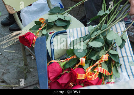 Ein Strauß roter Rosen mit katalanischen Flagge Bänder ruhen auf den Lehrstuhl für ein blumengeschäft Stall bereit während der Sant Jordi feiern in Barcelona verkauft zu werden. Stockfoto