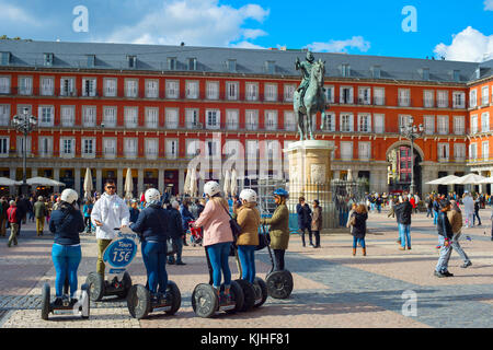 Madrid, Spanien - 07.November 2016: eine Gruppe von Touristen auf Segway auf einer Plaza Mayor vor der Statue des Königs Philips iii in Madrid Stockfoto