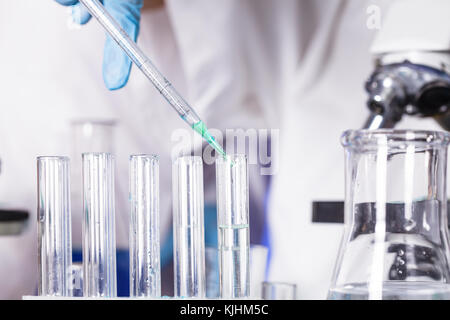 Die blauen Tropfen aus der Pipette im Labor Röhrchen Stockfoto