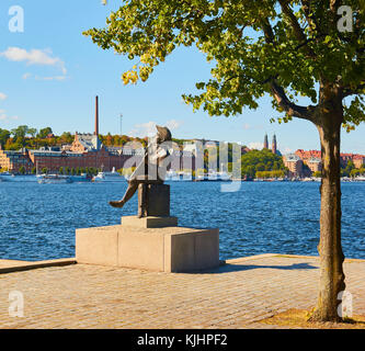 Statue von Evert Taube die Linie Troubadour der Schwedischen Ballade Tradition mit Vorort von Södermalm im Hintergrund, Riddarholmen, Stockholm, Schweden Stockfoto