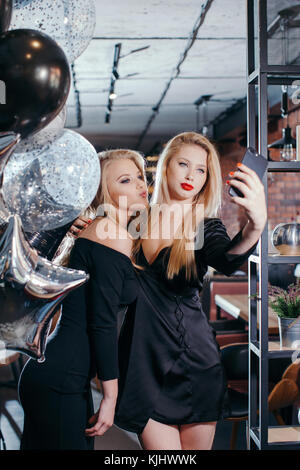 Zwei junge Frauen, die in einem Cafe selfies Stockfoto