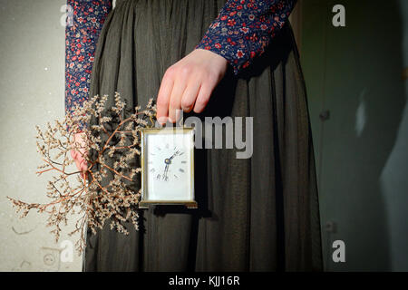 Mädchen mit Vintage kleid Wecker in der Hand halten Stockfoto