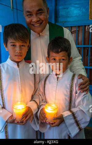 Vietnamesische katholische Ministranten und philippinischer Priester in Chong Khnies Kirche. Kambodscha. Stockfoto