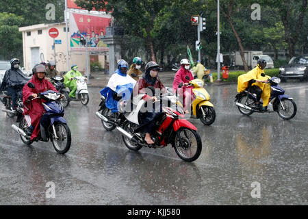 Schwere Monsunregen. Vietnamesische Leute fahren Motorräder auf Saigon Straße. Ho Chi Minh City. Vietnam. Stockfoto