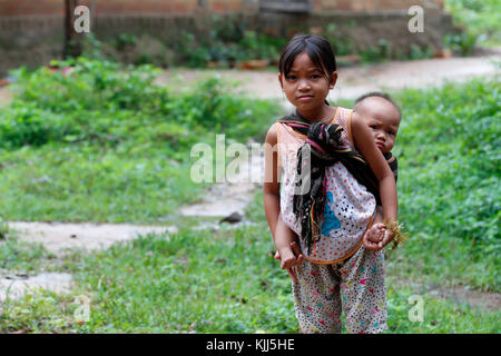 Bahnar (Ba Na) ethnische Gruppe. Junge Mädchen Baby auf dem Rücken. Kon Tum. Vietnam. Stockfoto