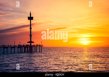 Die Menschen genießen den Sonnenuntergang vom Brighton Pier, South Australia Stockfoto