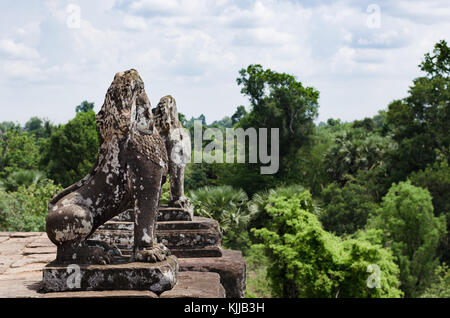 Zwei unkenntlich steinernen Löwen bewachen die obere Terrasse von Pre Rup Tempel im archäologischen Park Angkor Wat in Kambodscha. Stockfoto