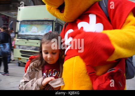 Ein Mädchen mit einem lustigen Riese kostüm Teddybär. Stockfoto