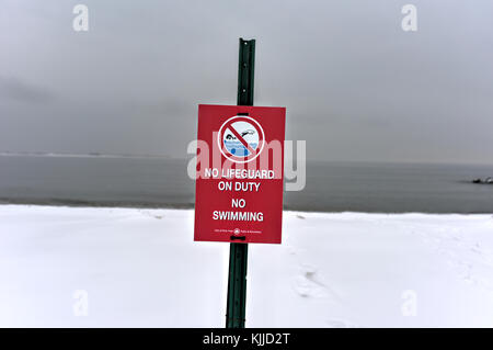 Winter Schnee am Strand. Schild deutlich hervorgeht, kein Schwimmen. Stockfoto