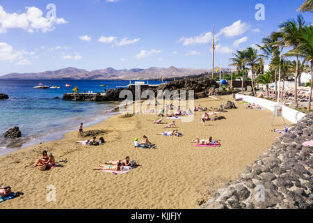 LANZAROTE, SPANIEN-4. Nov 2017: Playa Chica ist ein beliebter Strand, der für alle geeignet ist, von jungen Familien bis hin zu einem Wassersport mit Tauchschule Stockfoto