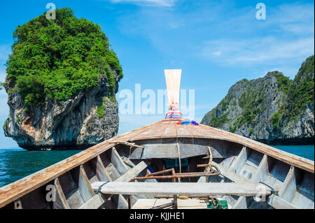 Traditionelle thailändische Holz- Longtail Boot mit dramatischen karst Geographie Auf dem Weg in der Bucht von Phi Phi Island zu Maya Stockfoto