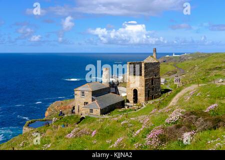 Ehemaliges Bergwerk für Kupfer und Zinn, Levant Mine, hinten der Leuchtturm Pendeen Lighthouse, St Just in Penwith, Cornwall, England, Großbritannien Stockfoto
