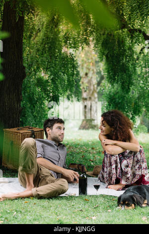 Paar mit Hund bei einem Picknick in einem Park Stockfoto
