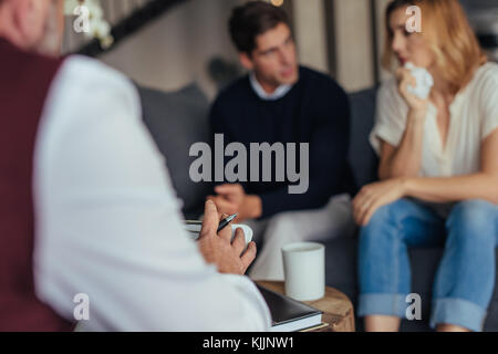 Psychologe consulting junges Paar in Schwierigkeiten. Psychotherapeut nehmen Sie sich Notizen während der Beratung. Stockfoto