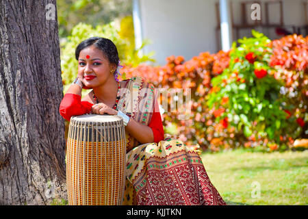 Assamesisch Mädchen in traditioneller Kleidung mit einem Dhol (Trommel), Pune, Maharashtra posieren. Stockfoto